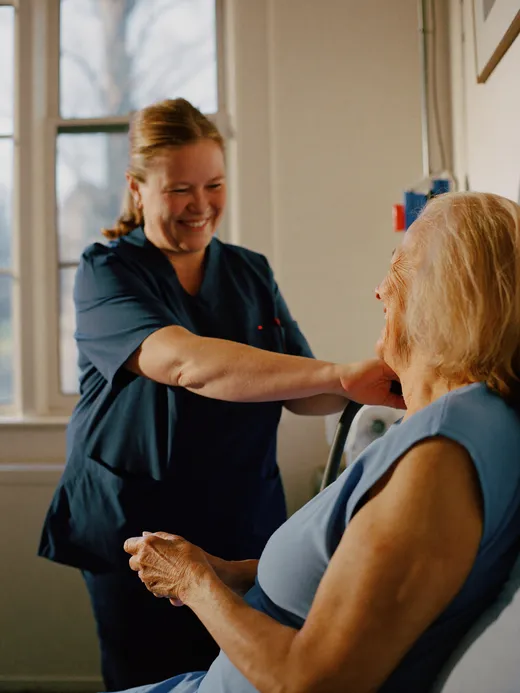 A CRMC nurse shares a laugh with a patient in a sunlit room